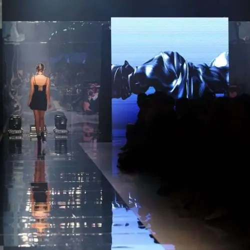 Black dress High heels Model walk back on mirror Runway Fashion Show catwalk with reflection on floor lighting along walk way, background stage ramp, copy space for text logo